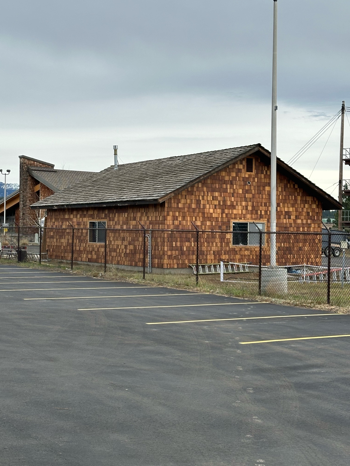 Before photo of McCall Smoke Jumper Base main building side — original cedar shake siding showing age and weathering